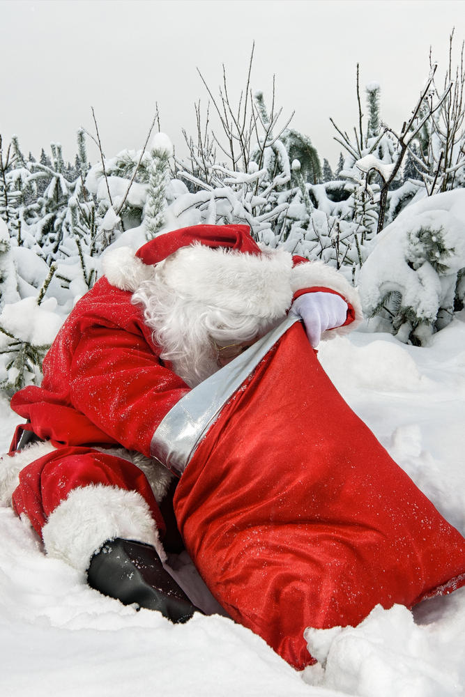 Santa Claus avec sa hotte dans la neige.