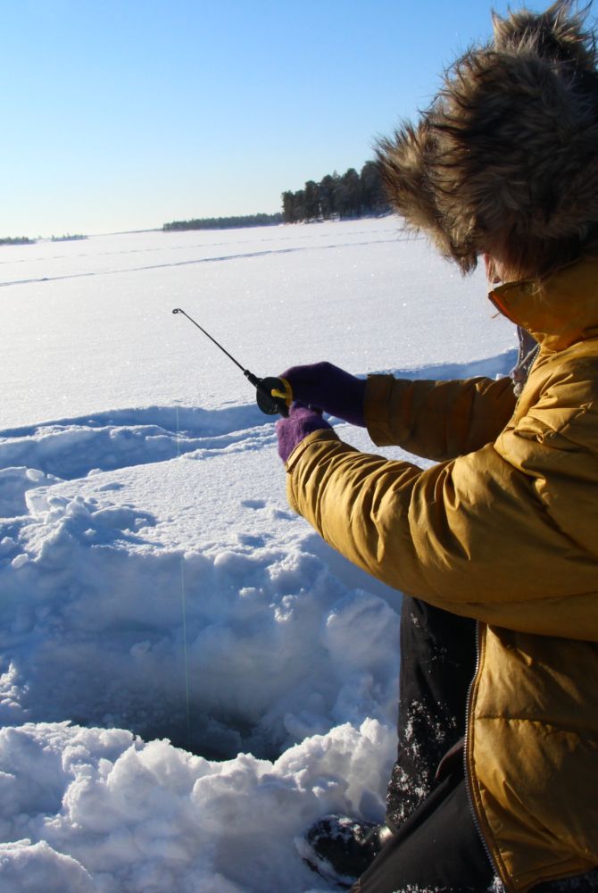 Pêcher sous la glace en Laponie requiert de la patience.